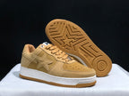 Angled view of the sneakers with one shoe lifted to show the gum outsole and star tread pattern.