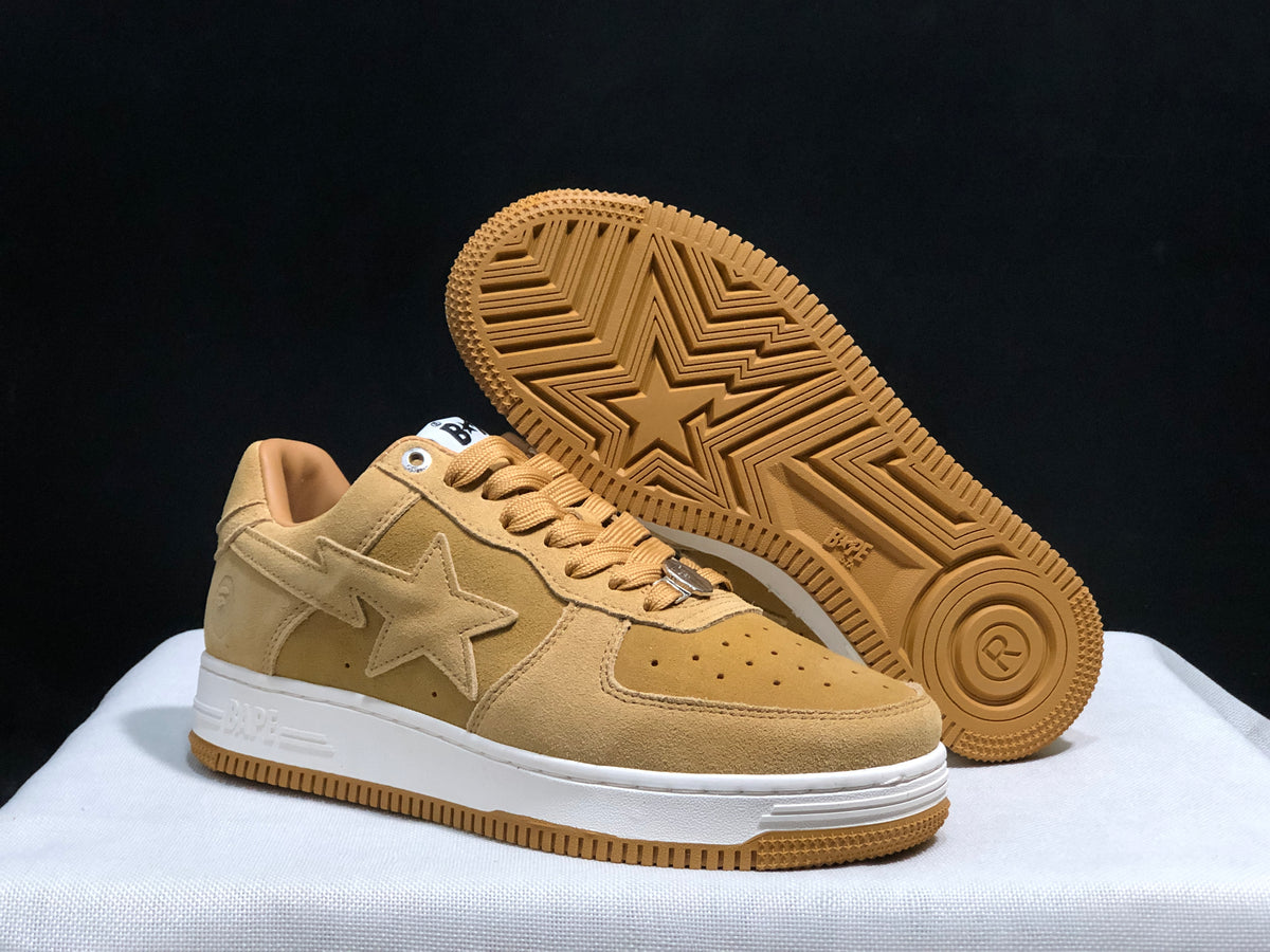 Angled view of the sneakers with one shoe lifted to show the gum outsole and star tread pattern.