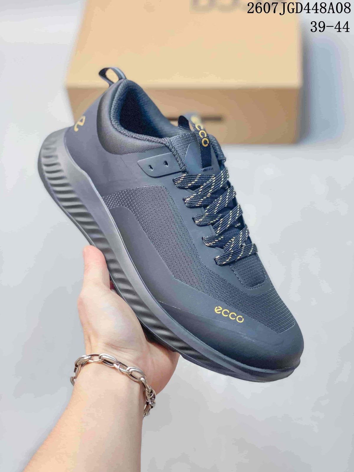 Angled side view of a dark gray ECCO sneaker showing the lace-up construction, padded collar, pull tab, and molded outsole.