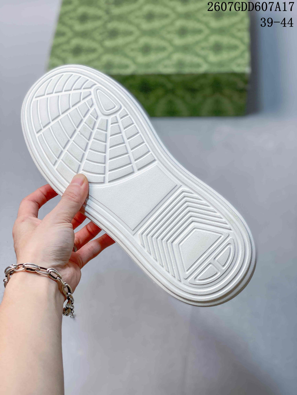 Close-up of the white sneaker outsole showing its geometric tread pattern.