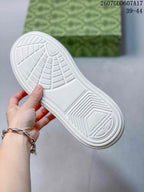 Close-up of the white sneaker outsole showing its geometric tread pattern.