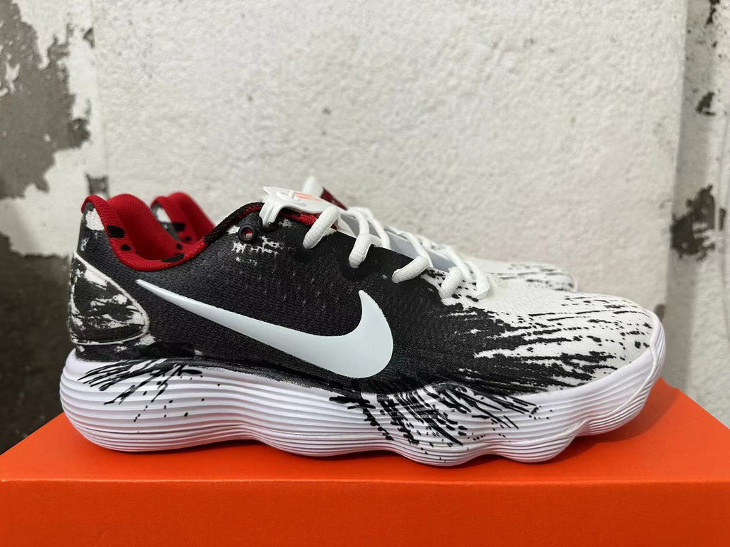 Side view of a patterned Nike shoe with a white Swoosh and red lining