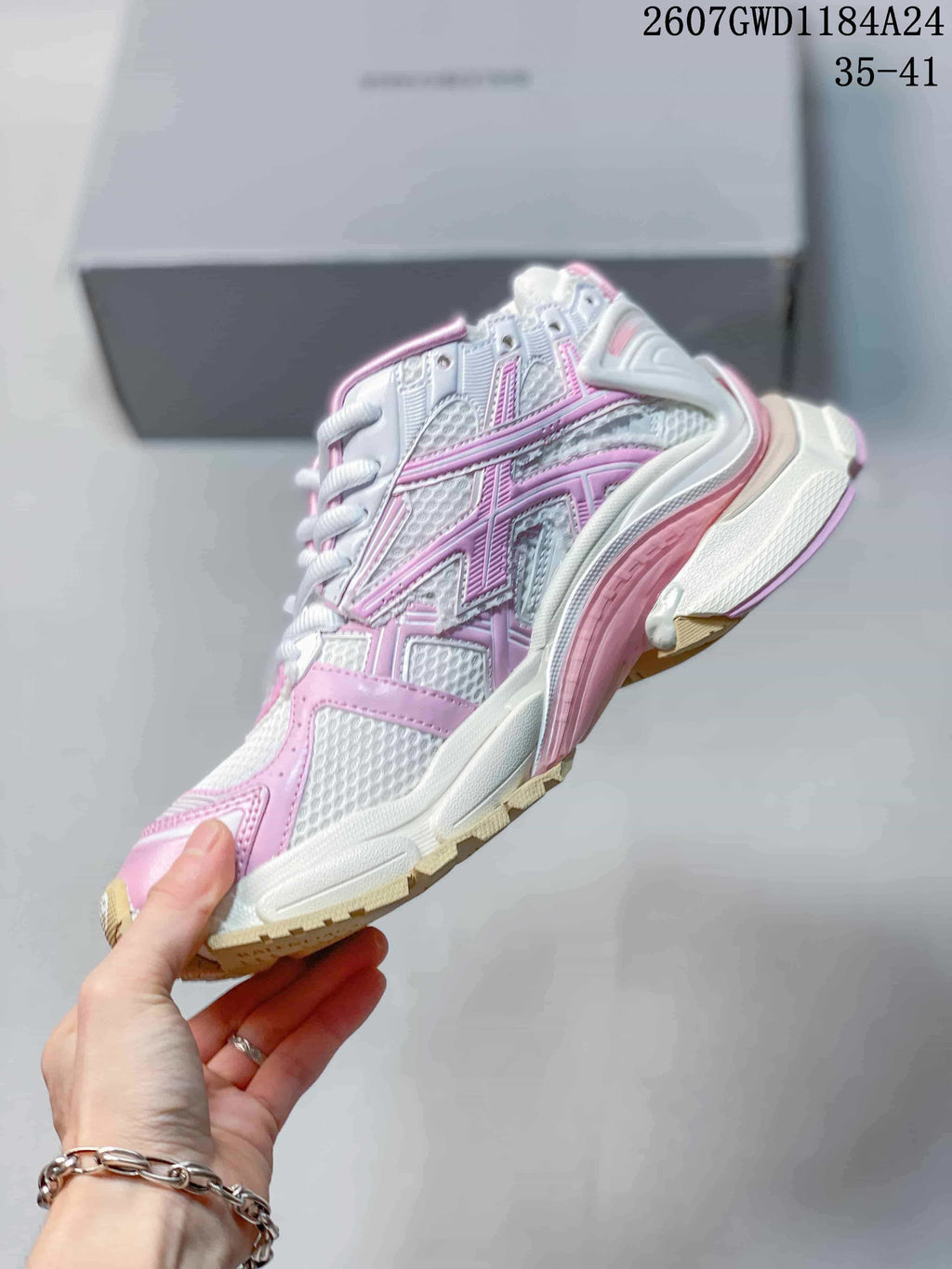Side profile showing the layered pink and white upper, mesh-style panels, and chunky sole.