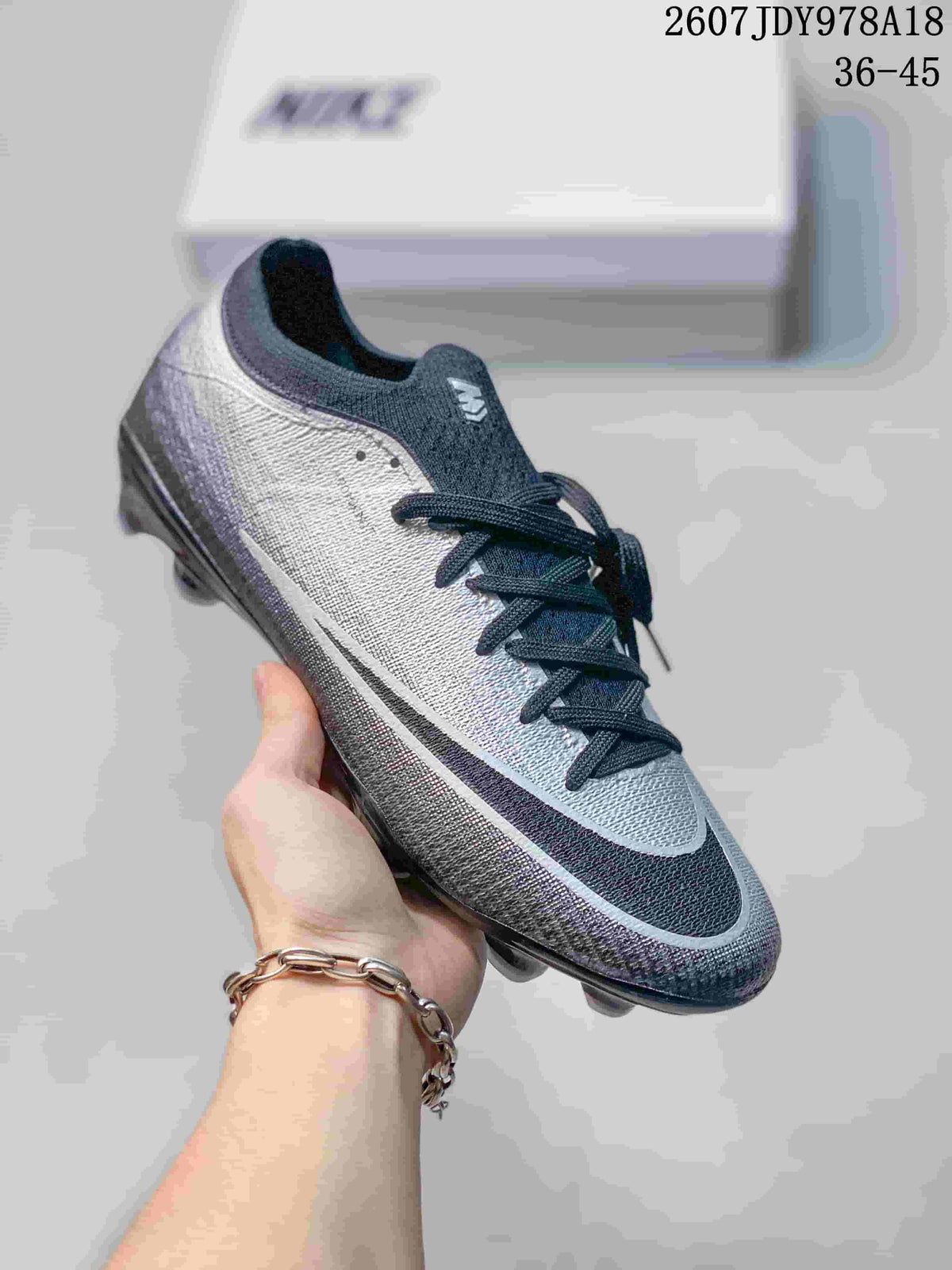 Black and gray Nike soccer cleat with a dark outsole and contrasting light side detail.