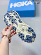 Underside view of the shoe showing the blue-and-cream patterned outsole with directional lugs.