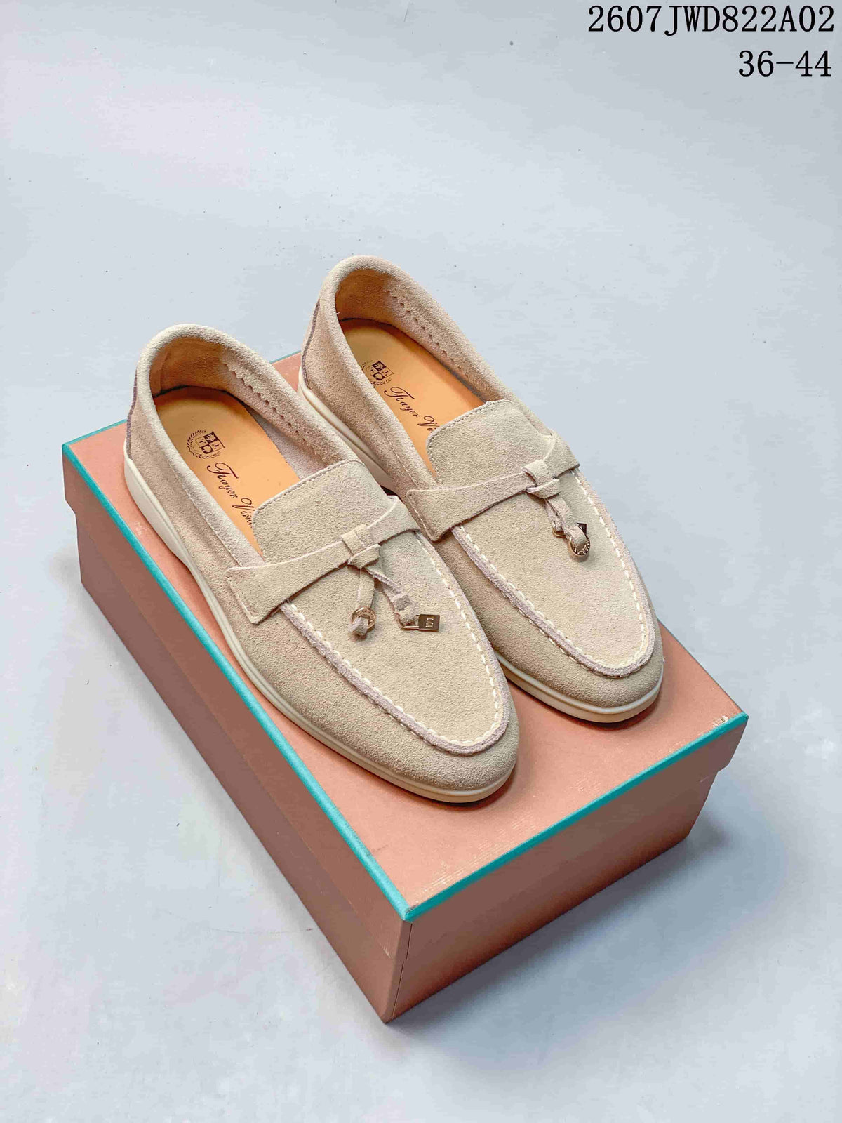 Pair of light beige loafers with strap and decorative tassel details
