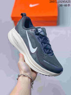 Angled side view of the Nike Vomero 18 showing the dark upper, white Swoosh, pull tab, raised midsole, and visible ZoomX marking.