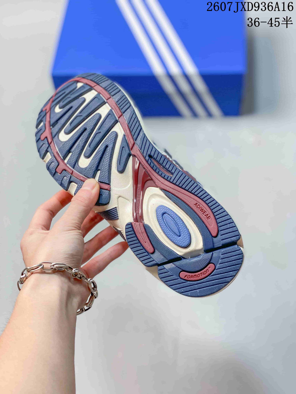 Close view of the patterned outsole showing blue, cream and burgundy sections and raised tread details.