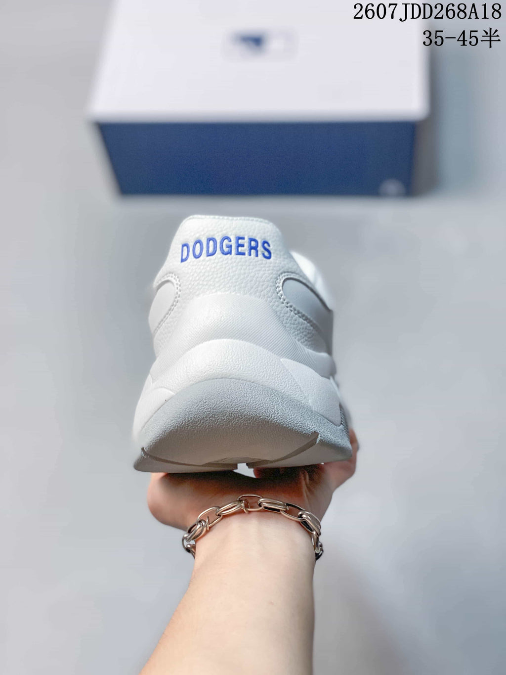 Rear view of the white sneaker showing blue Dodgers lettering on the padded heel.