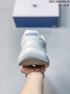 Rear view of the white sneaker showing blue Dodgers lettering on the padded heel.