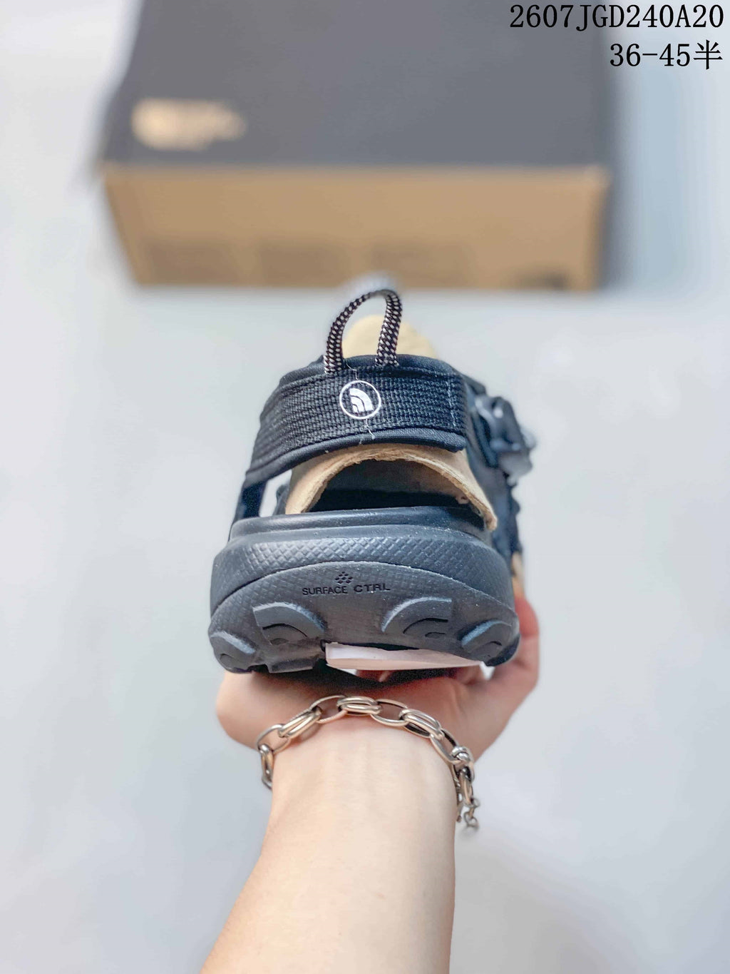 Rear view of a sandal showing the heel strap, pull loop, outsole, and Surface Ctrl marking.