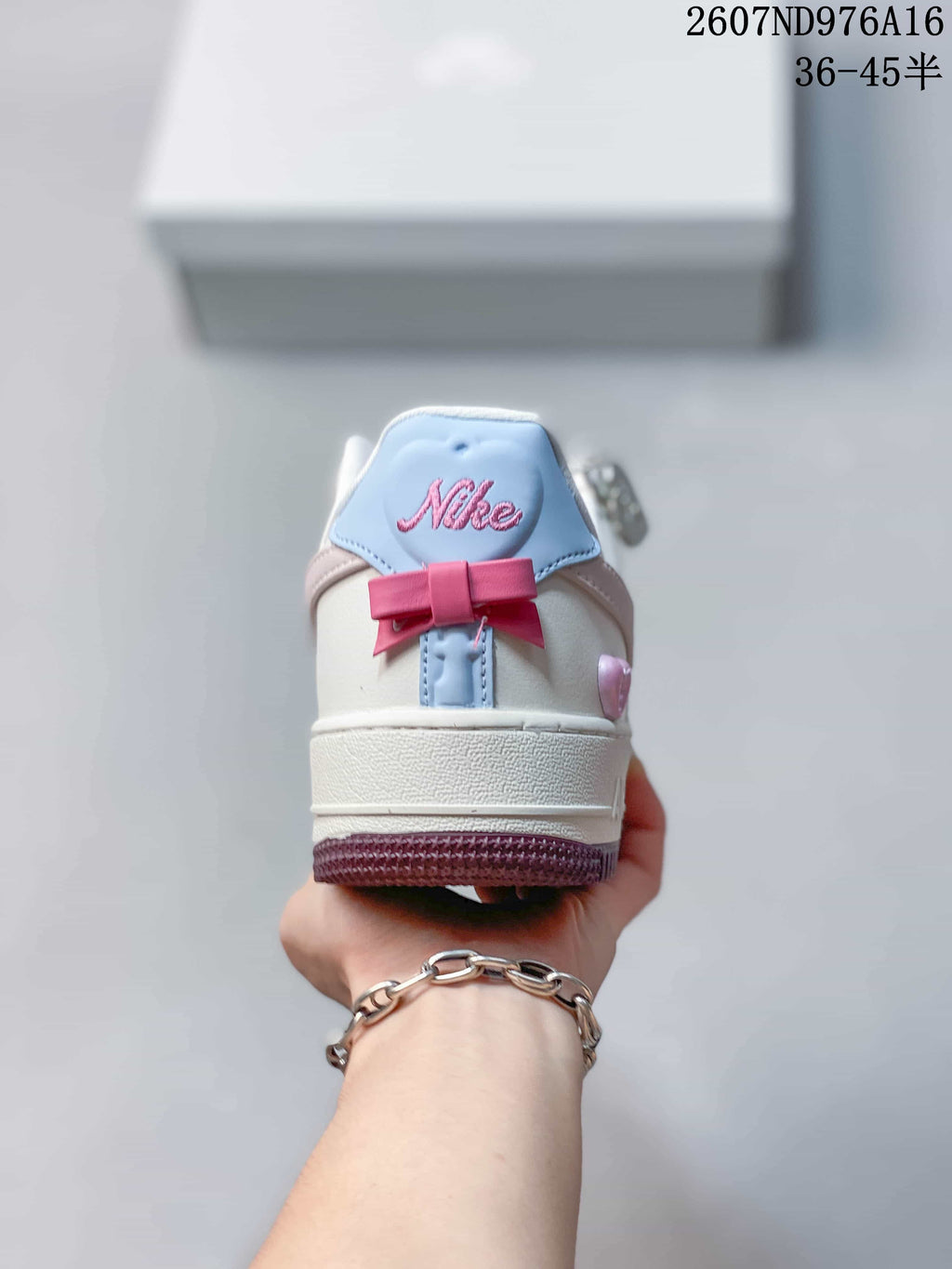Rear view showing the white heel, blue heel tab and pink bow detail.
