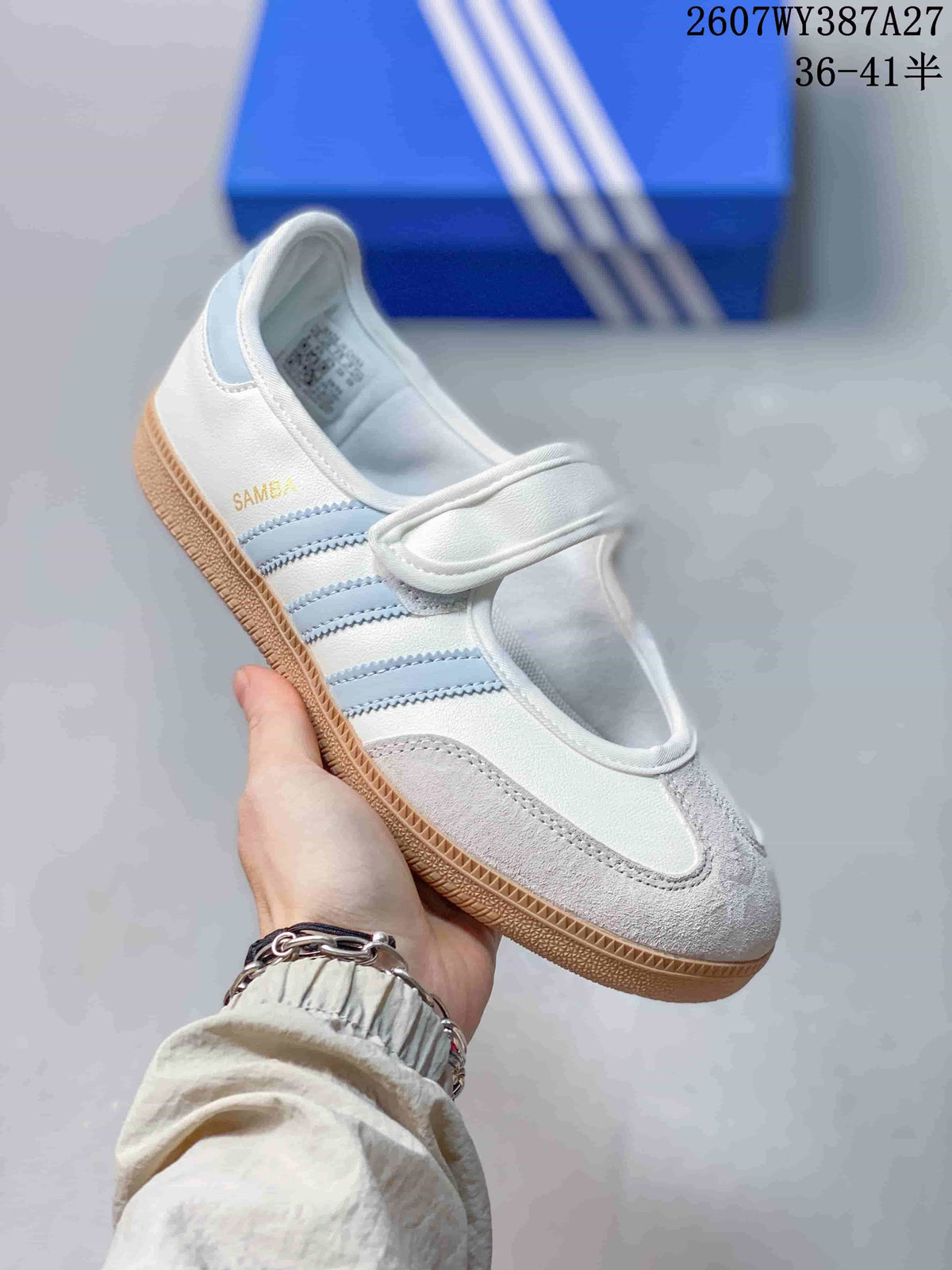 Close-up of a white Samba Jane sneaker with light blue stripes, a hook-and-loop strap and gum-style outsole.