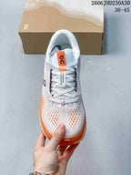 Top view of a white and orange lace-up sneaker