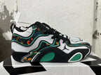 Side view of a Jordan basketball shoe with white panels, green accents, and multicolor floral detailing.