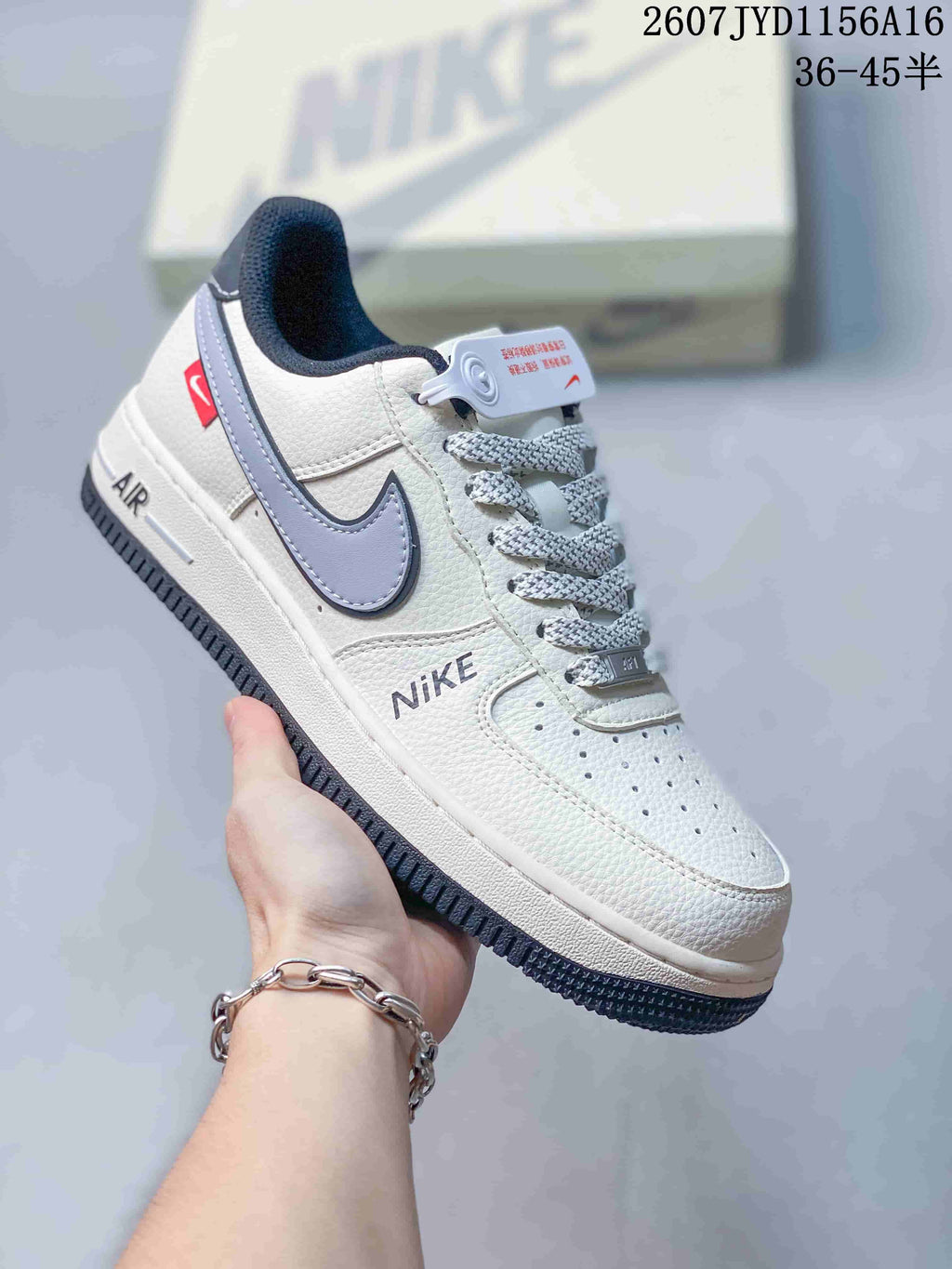 Close-up side view of a white sneaker with grey Swoosh, perforated toe box, lace-up front, and Air sole branding.