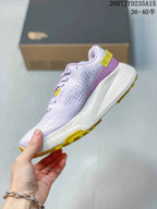 Side view of the low-top hiking shoe showing the textured upper, purple heel accent, white midsole, and yellow outsole.