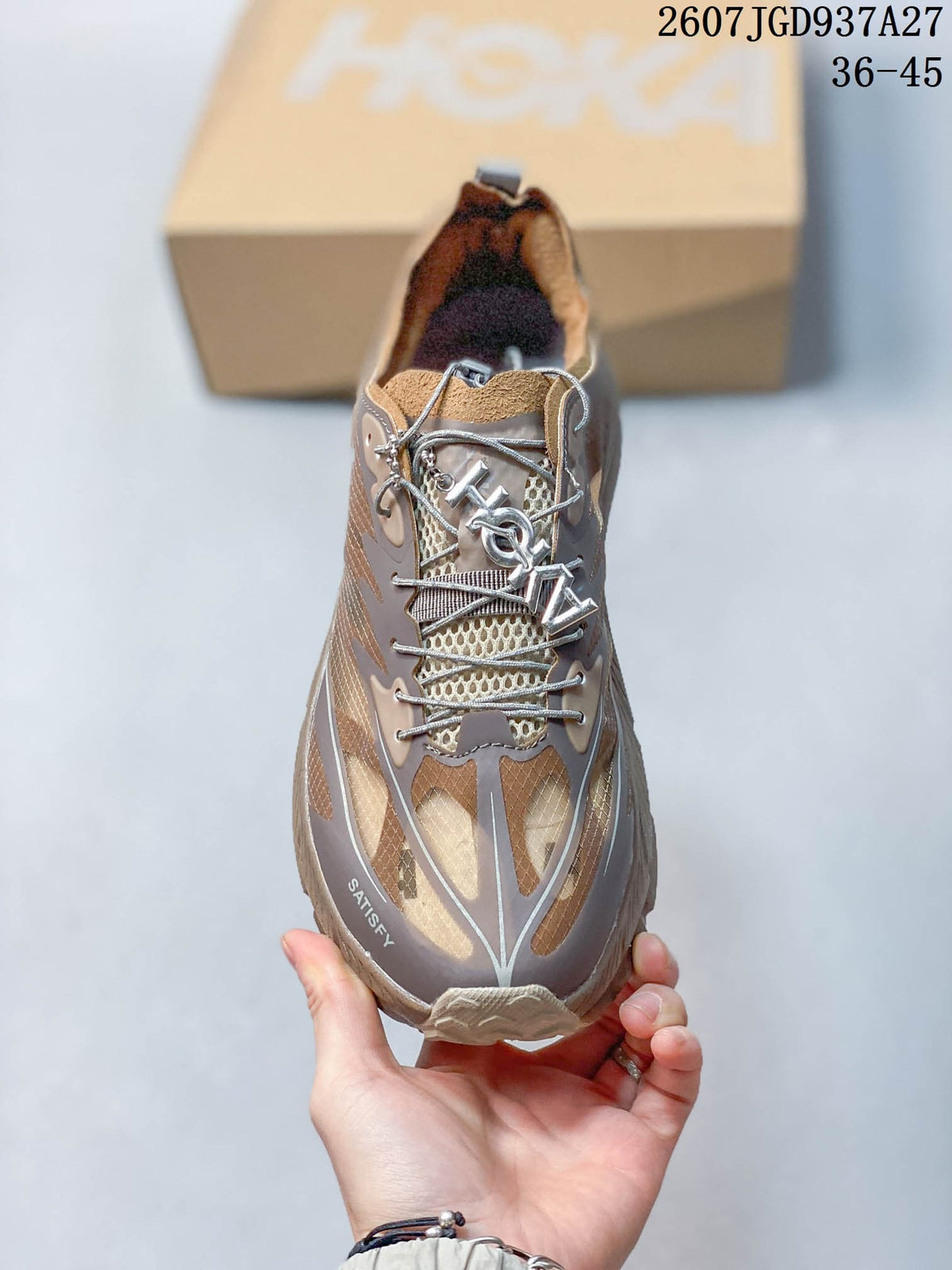 Top view of a SATISFY sneaker showing the lacing system, patterned upper, and branded toe area.