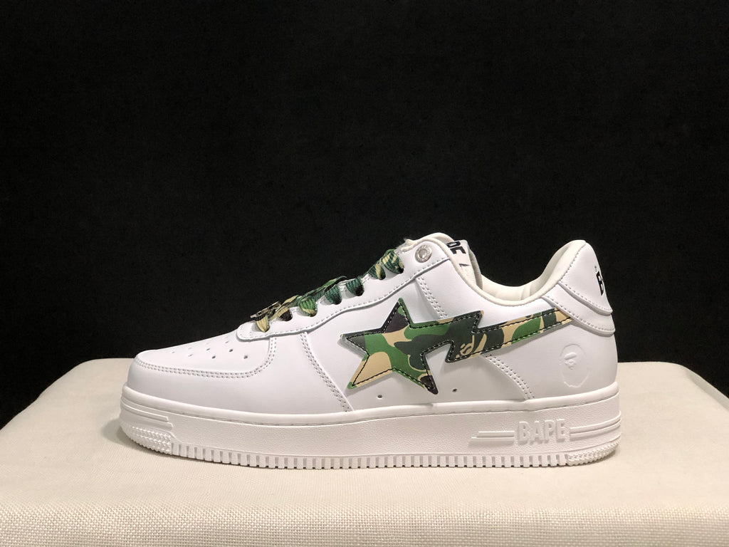 Side profile of a white BAPE STA sneaker showing the green camouflage star panel, padded collar, and white rubber sole.
