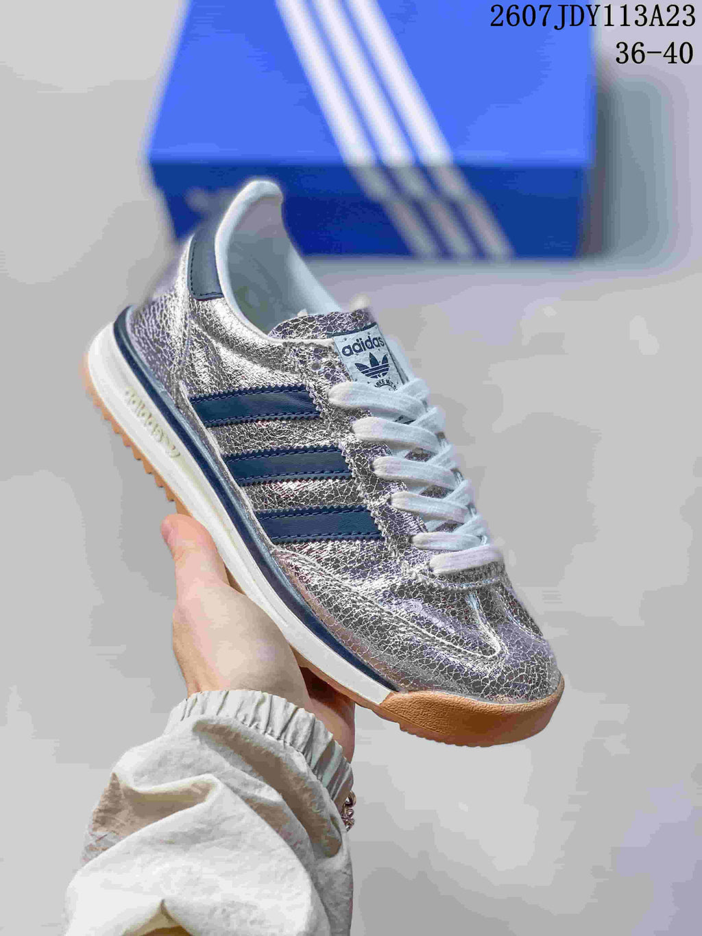 Metallic silver adidas SL 72 sneaker with navy side stripes, white laces and a gum-look outsole.