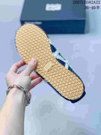 Underside view of the sneaker showing the gum-colored outsole and repeating patterned tread.