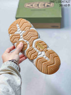 Close-up of the sandal outsole showing a segmented gum-colored tread pattern and KEEN branding.