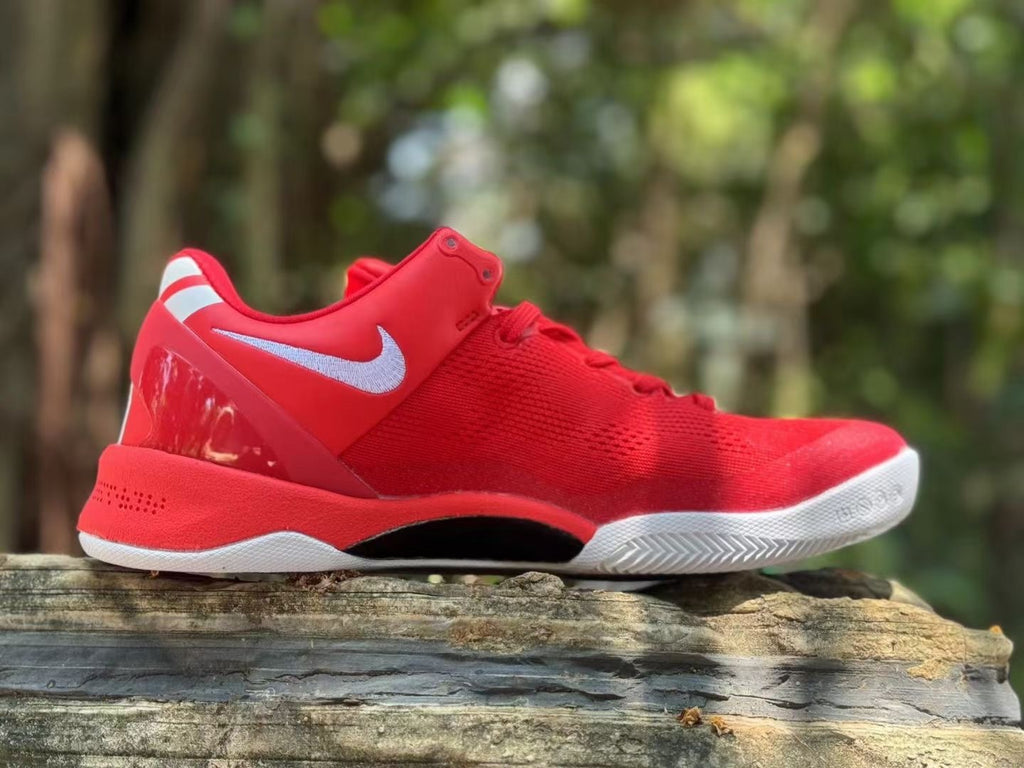 Side view of the red Nike Kobe 8 shoe showing its white logo and outsole