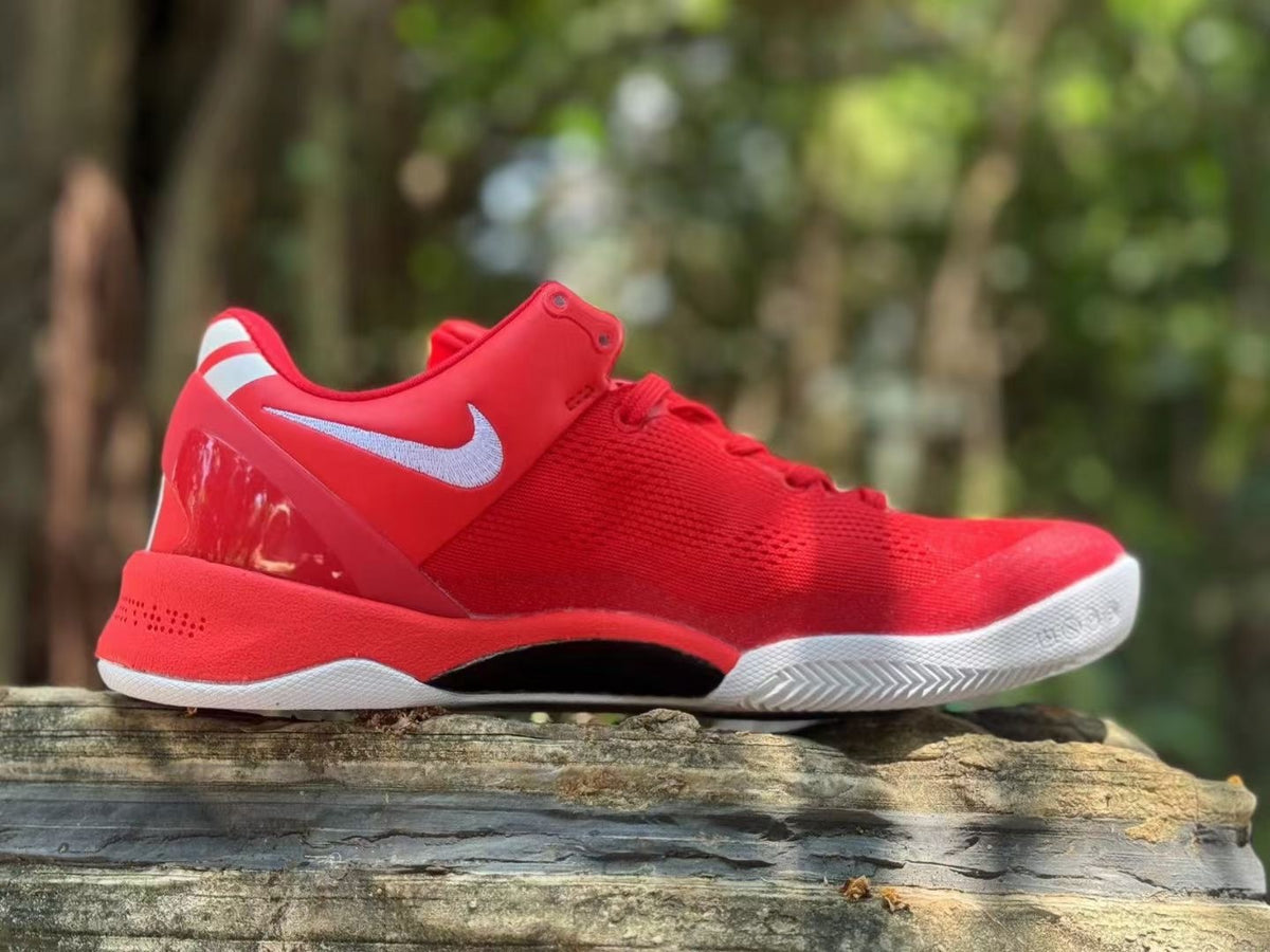 Side view of the red Nike Kobe 8 shoe showing its white logo and outsole