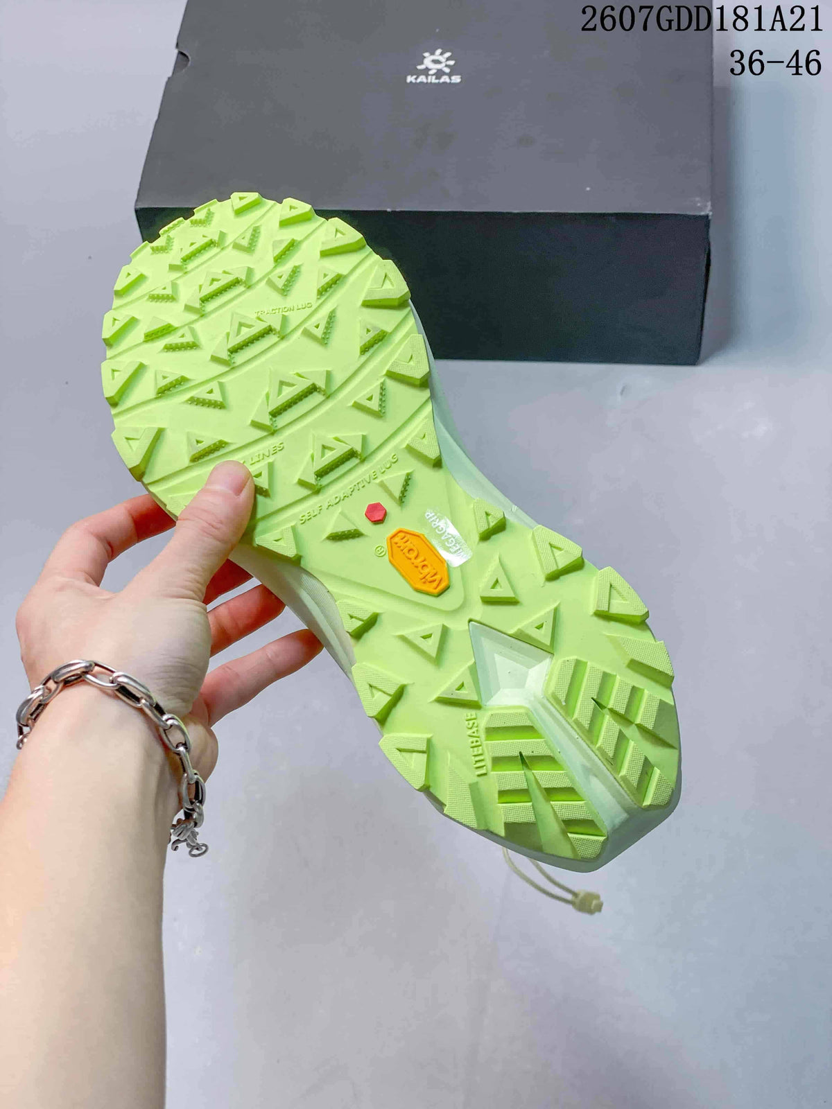 Close view of the shoe outsole showing a bright green lugged tread pattern and central traction details.