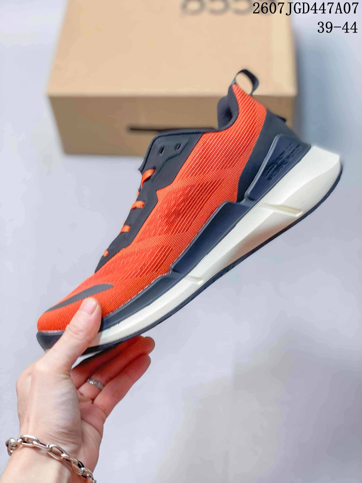 Side profile of an orange and navy ECCO sneaker showing the textured upper, dark overlays, lacing, and layered sole.