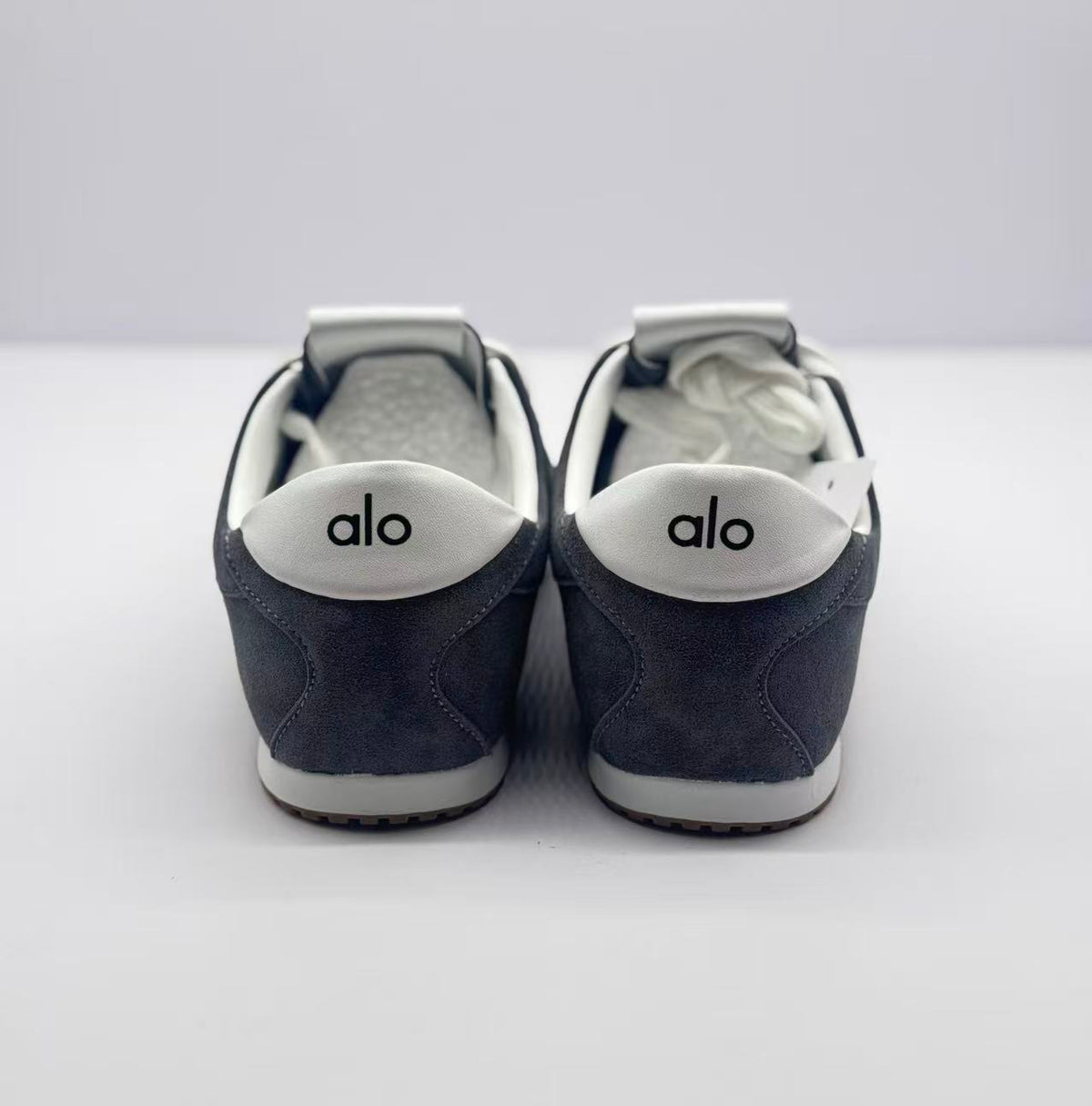 Rear view of the pair with Alo branding on the white heel accents.