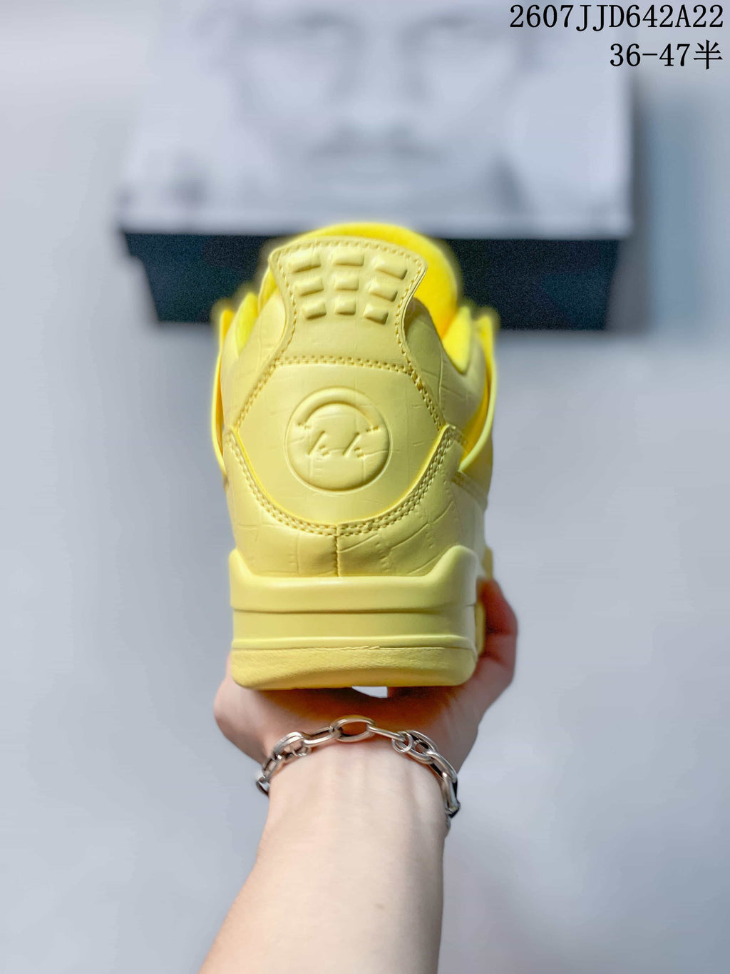 Rear view of the yellow sneaker showing the padded heel section and embossed circular detail.