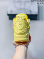 Rear view of the yellow sneaker showing the padded heel section and embossed circular detail.