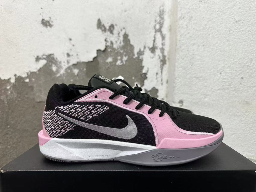Side view of a pink and black Nike Kobe basketball shoe with a gray Swoosh and patterned panel.