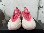 Front view showing the tongues, laces, and cream toe panels of the pink Adidas Dame 9 shoes