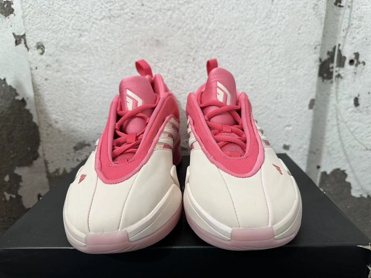 Front view showing the tongues, laces, and cream toe panels of the pink Adidas Dame 9 shoes