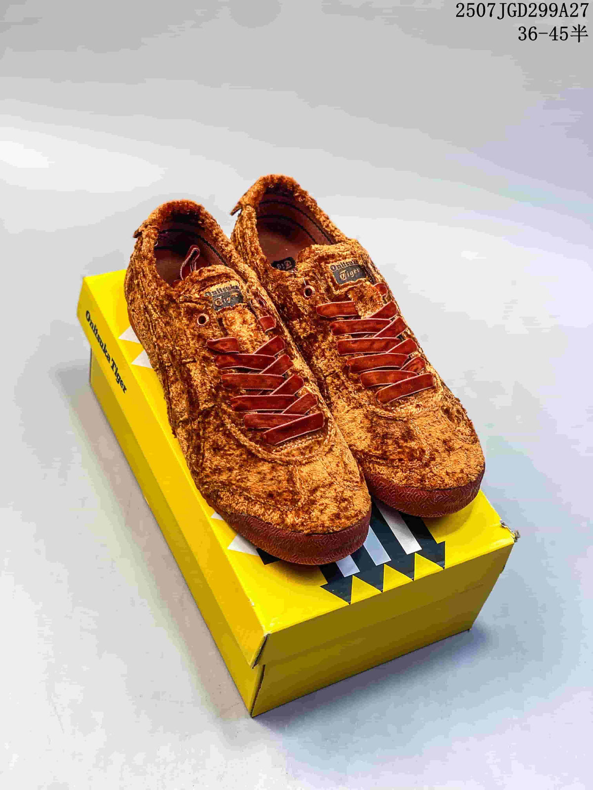 Pair of brown and golden-brown low-top sneakers displayed on a yellow branded shoe box.