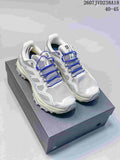 Pair of white and blue KAILAS low-top hiking shoes displayed on a shoebox, with blue laces and rugged outsoles.