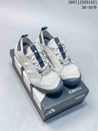 Pair of white and navy adidas Terrex hiking shoes displayed on a branded shoebox.