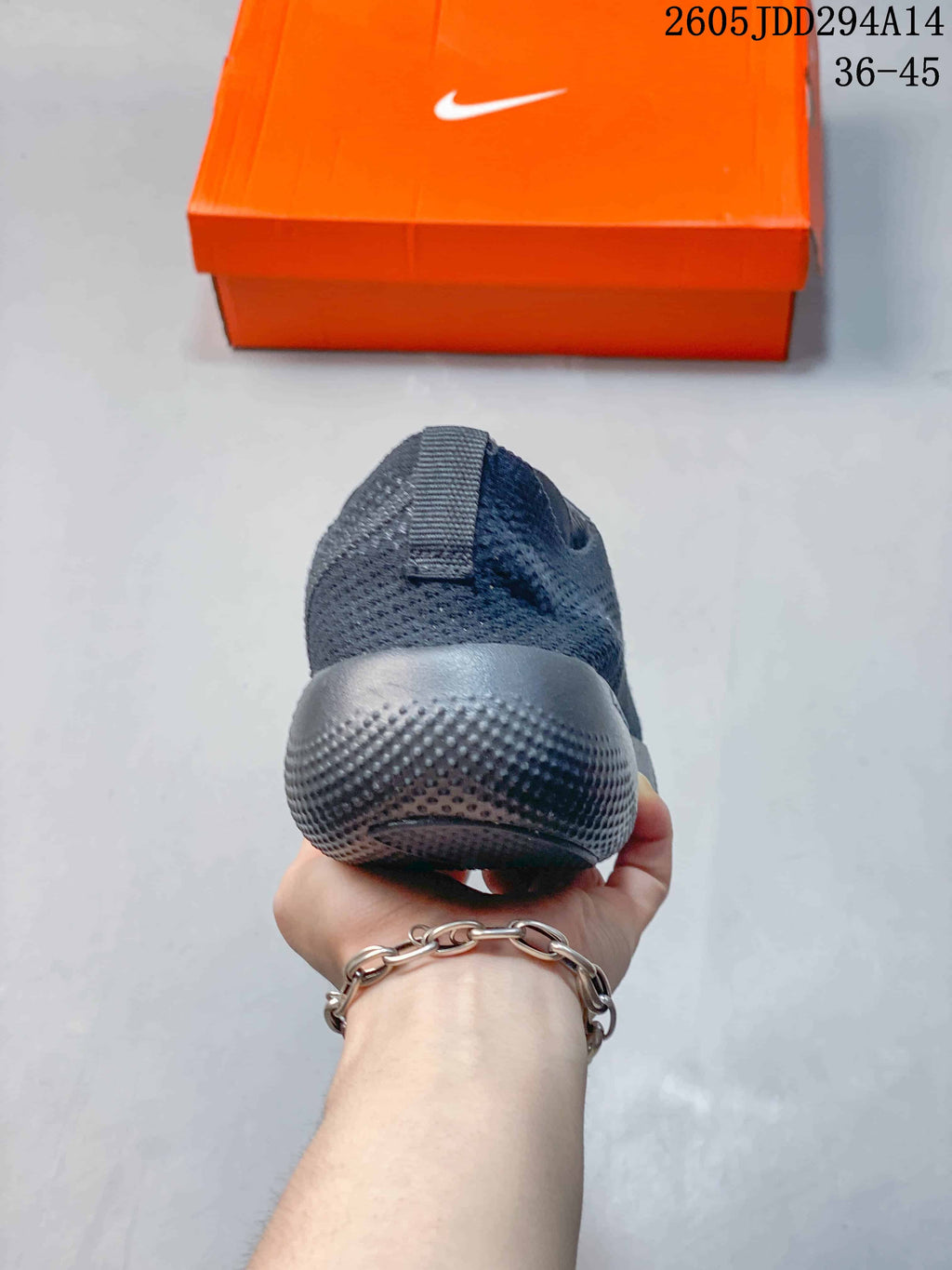 Rear view showing the padded heel and textured outsole of the dark gray Nike Free sneaker.