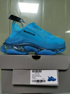 Side profile of the cyan blue sneaker resting on its box, with the box label identifying Triple S Clear Sole, Cyan Blue, and size C 37.