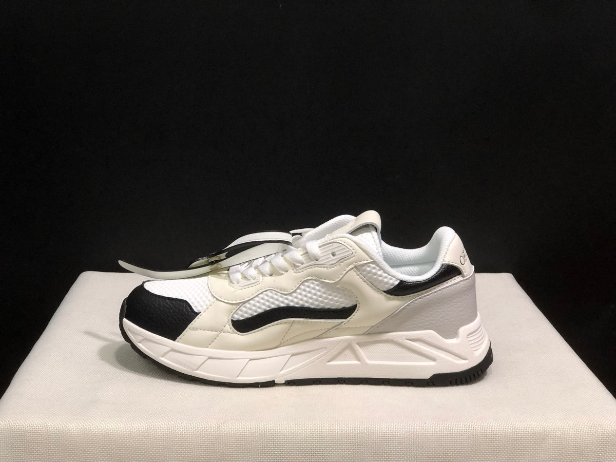Outer side profile of one sneaker showing the layered side panels, black accent strip, and sculpted white midsole.