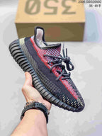 Black, gray and red Adidas Yeezy-style sneaker with a textured upper and ridged sole.