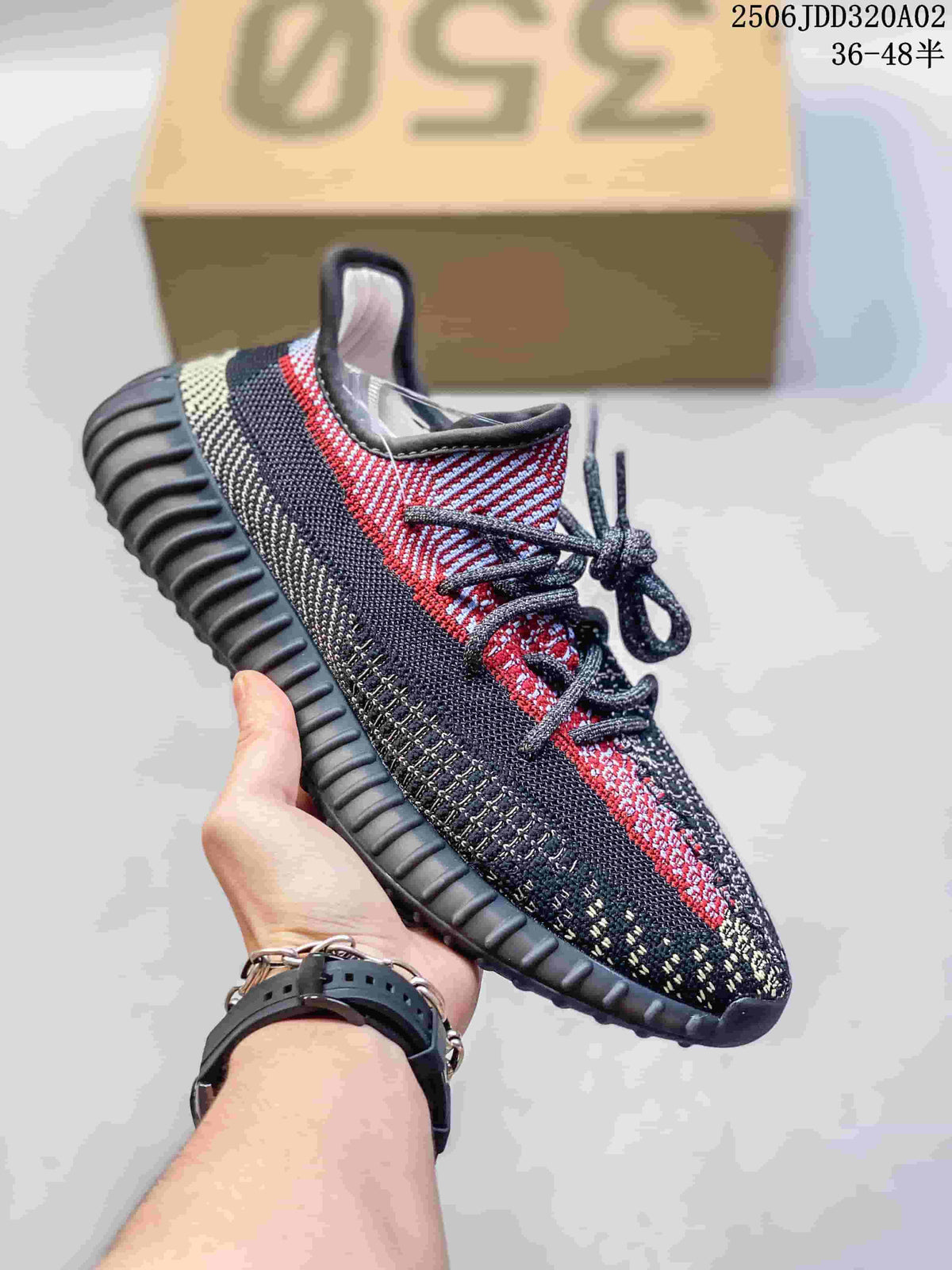 Black, gray and red Adidas Yeezy-style sneaker with a textured upper and ridged sole.