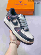 Dark navy and cream low-top sneaker with monogram-print panels and contrast swoosh details.
