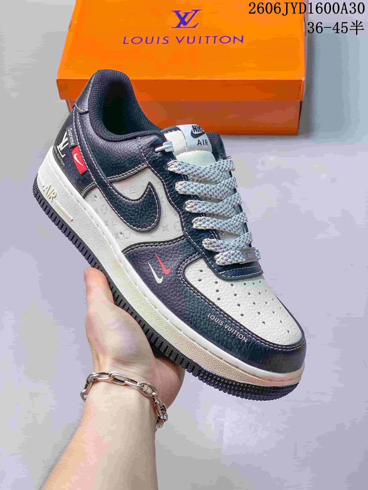 Dark navy and cream low-top sneaker with monogram-print panels and contrast swoosh details.