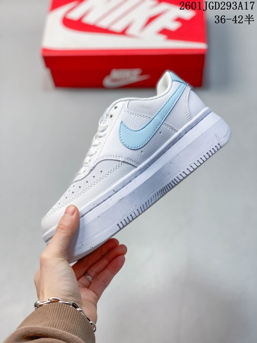 Side view showing the light blue Swoosh, white upper and platform-style sole.