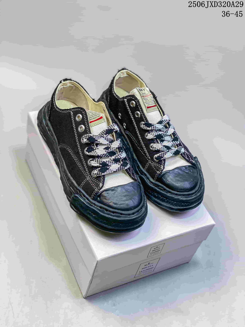 Pair of black MMY Blakey sneakers on a shoebox, showing white stitching, patterned laces and sculpted soles; style code 2506JXD320A29 and size range 36-45 are visible.