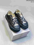 Pair of black MMY Blakey sneakers on a shoebox, showing white stitching, patterned laces and sculpted soles; style code 2506JXD320A29 and size range 36-45 are visible.