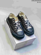 Pair of black MMY Blakey sneakers on a shoebox, showing white stitching, patterned laces and sculpted soles; style code 2506JXD320A29 and size range 36-45 are visible.
